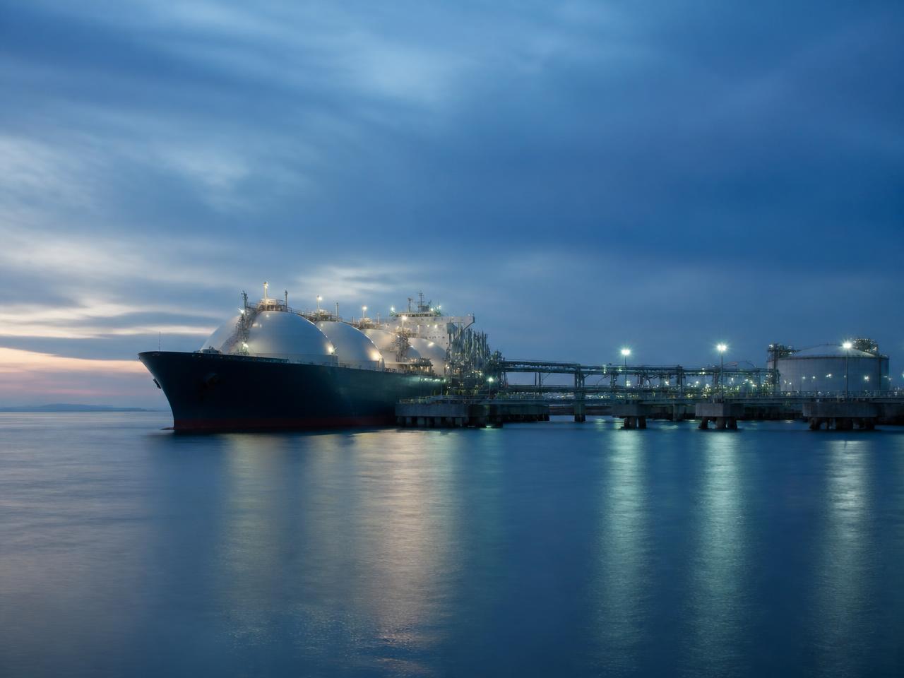 LNG tanker berthed at an export terminal at dawn